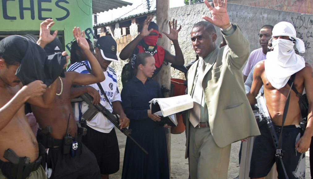 Sur cette photo prise le 31 mars 2009, le pasteur Andre Assis, au centre, prie avec des trafiquants de drogue présumés dans un bidonville de Rio de Janeiro. / Keystone
